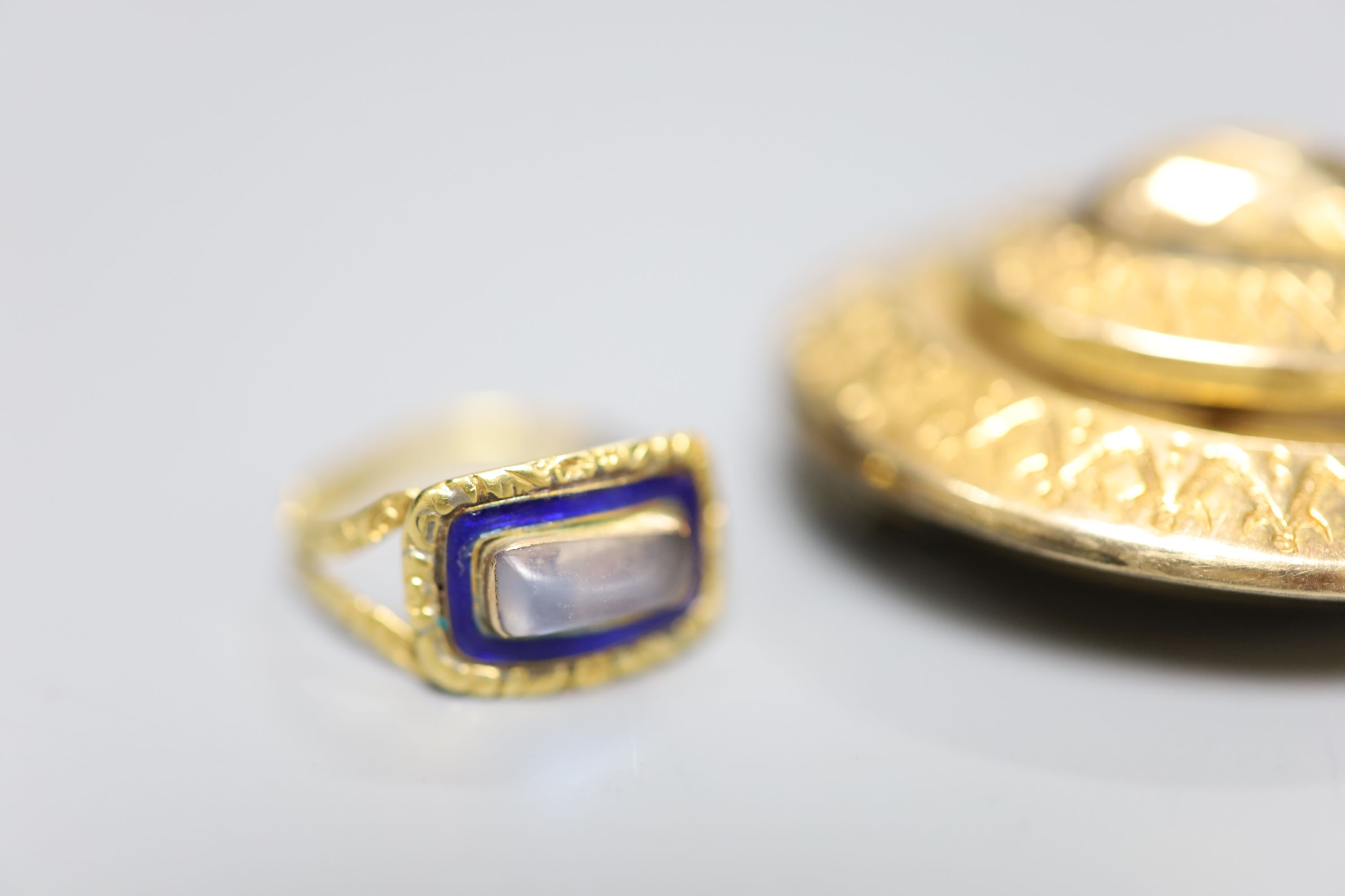 A Georgian yellow metal, enamel and moonstone set mourning ring, pendant and brooch